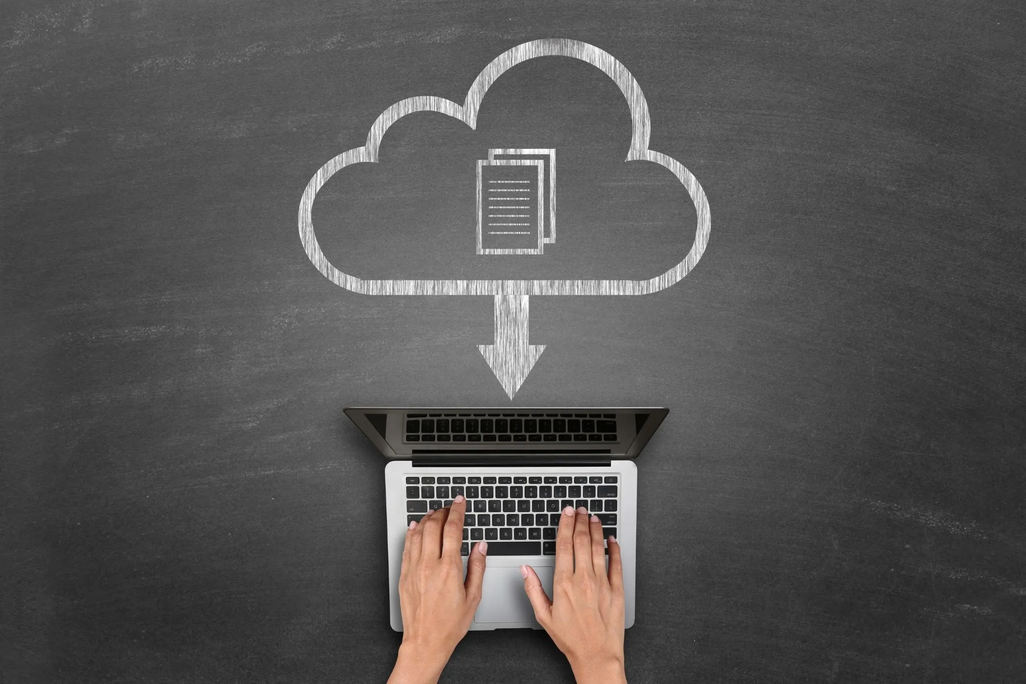 A chalkboard-style illustration showing a large cloud icon with a document symbol inside it and a downward arrow pointing to an open laptop below. A pair of hands is typing on the laptop keyboard.